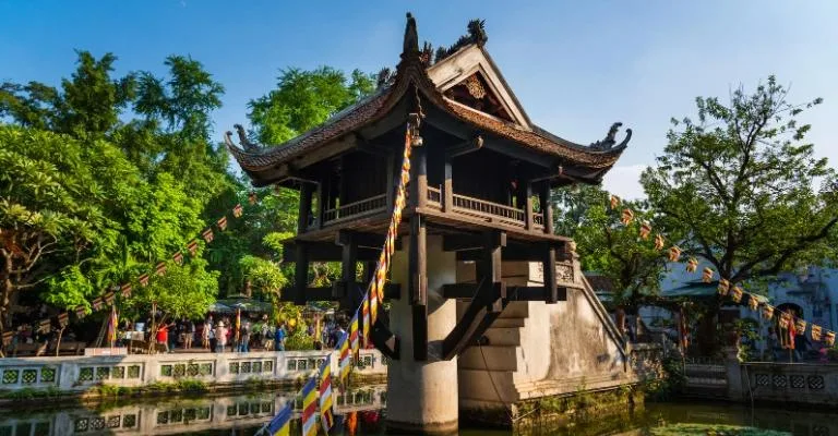 The One Pillar Pagoda on stilts above a lotus pond in Hanoi, decorated with colorful prayer flags