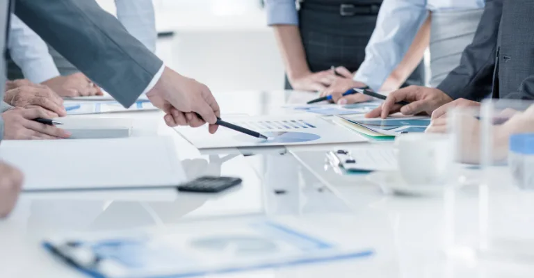 Business team reviewing charts and reports together around a conference table