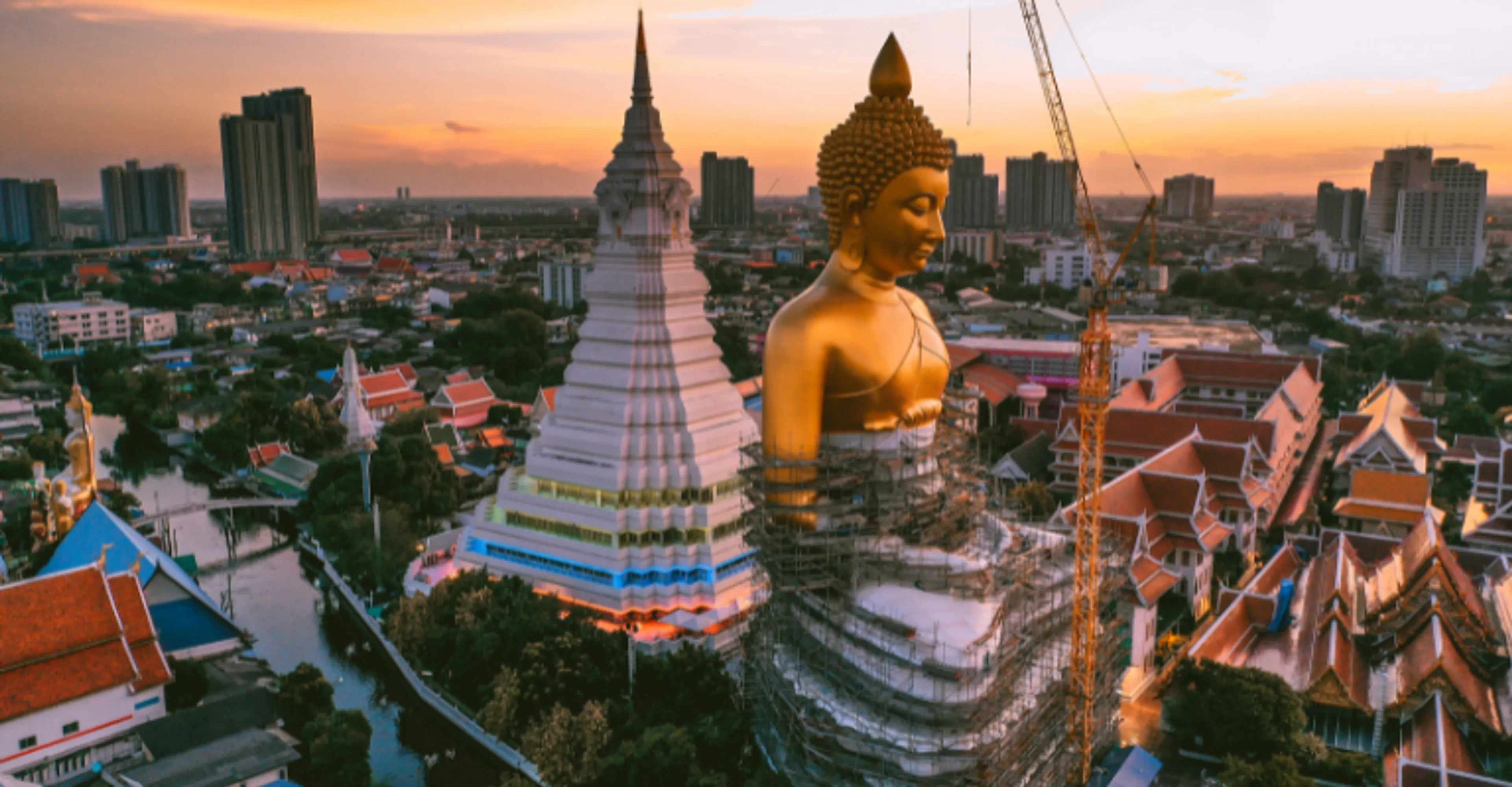 Giant golden Buddha at Wat Paknam overlooking Bangkok at sunset