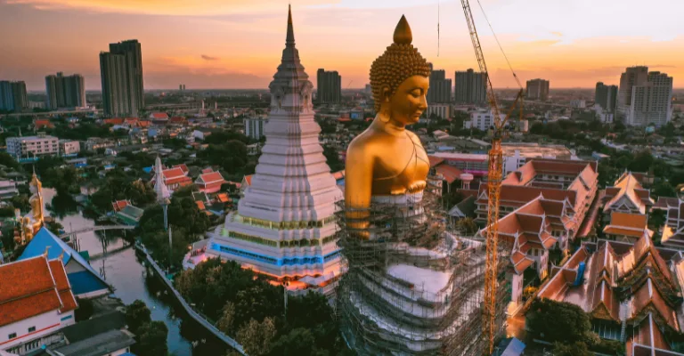 Giant golden Buddha at Wat Paknam overlooking Bangkok at sunset