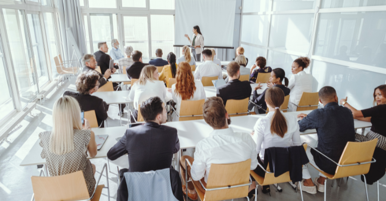 Business delegates attending a MICE conference session in a modern seminar room