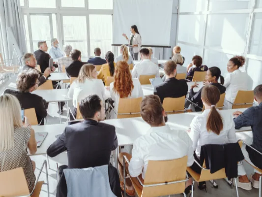 Business delegates attending a MICE conference session in a modern seminar room