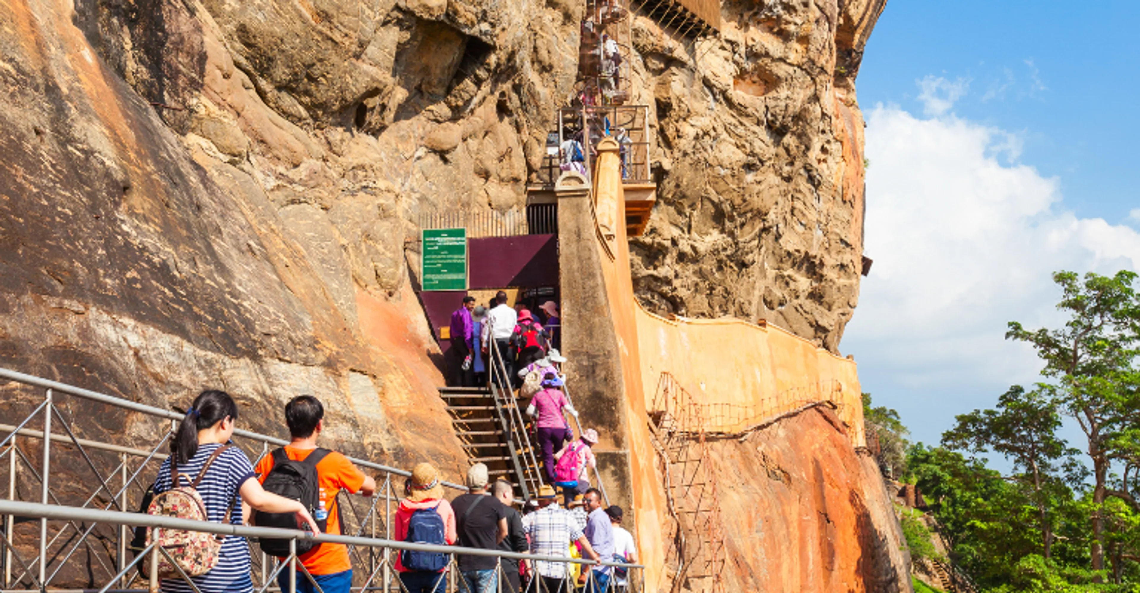 Visitors climbing the stairway carved into Sigiriya Rock Fortress