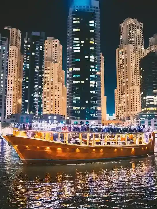 Traditional dhow cruise in Dubai Marina with illuminated skyline at night