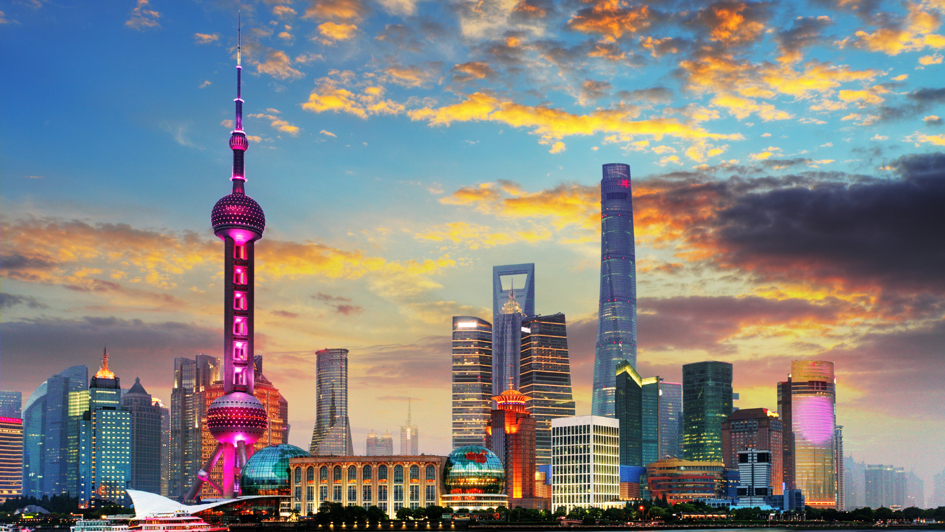 Shanghai skyline at sunset with the Oriental Pearl Tower and skyscrapers.