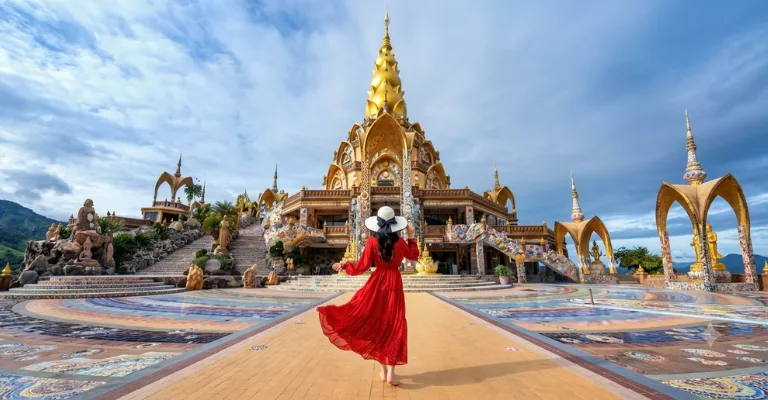 Woman in a red dress at the golden Wat Pha Sorn Kaew temple, Thailand