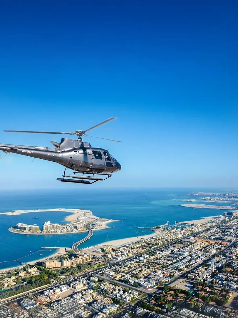 Helicopter flying over Dubai skyline with Burj Khalifa and Palm Jumeirah aerial view