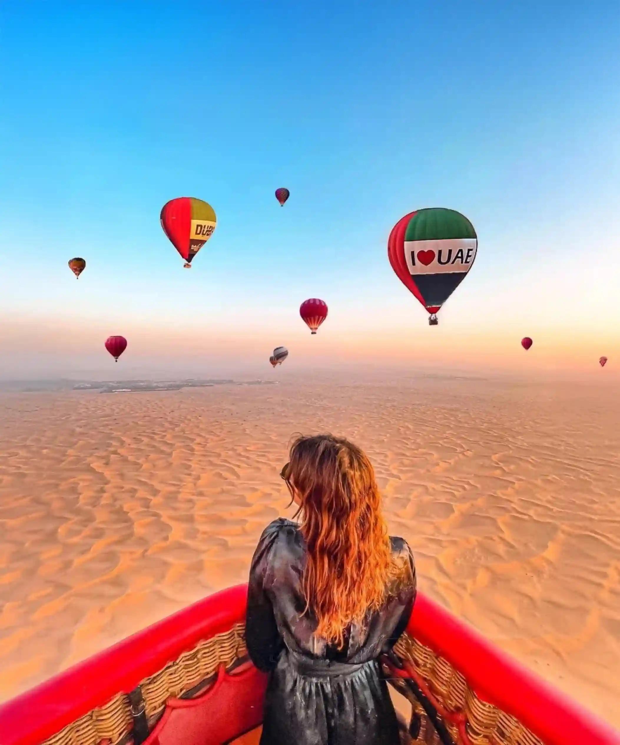 Hot air balloon flying over the Dubai desert at sunrise