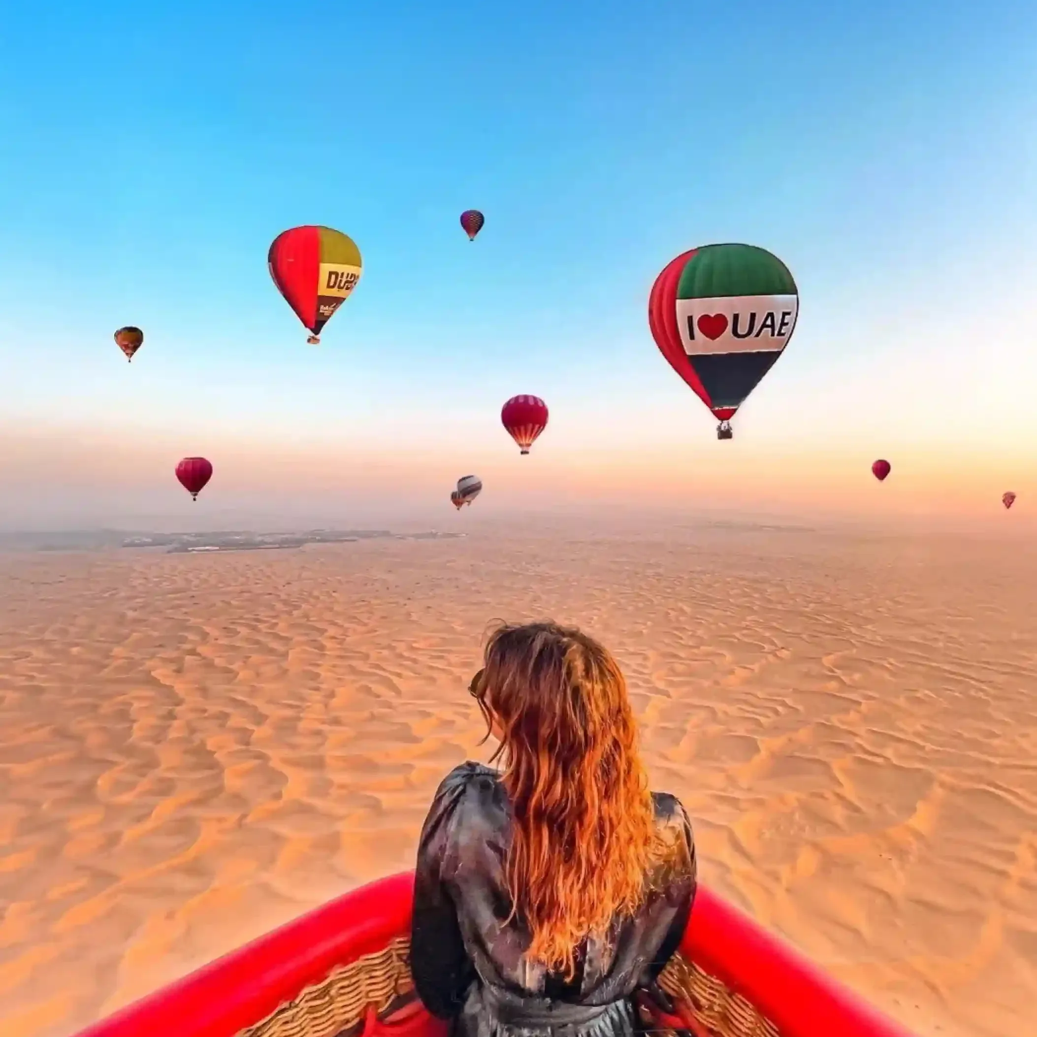 Hot air balloon flying over the Dubai desert at sunrise
