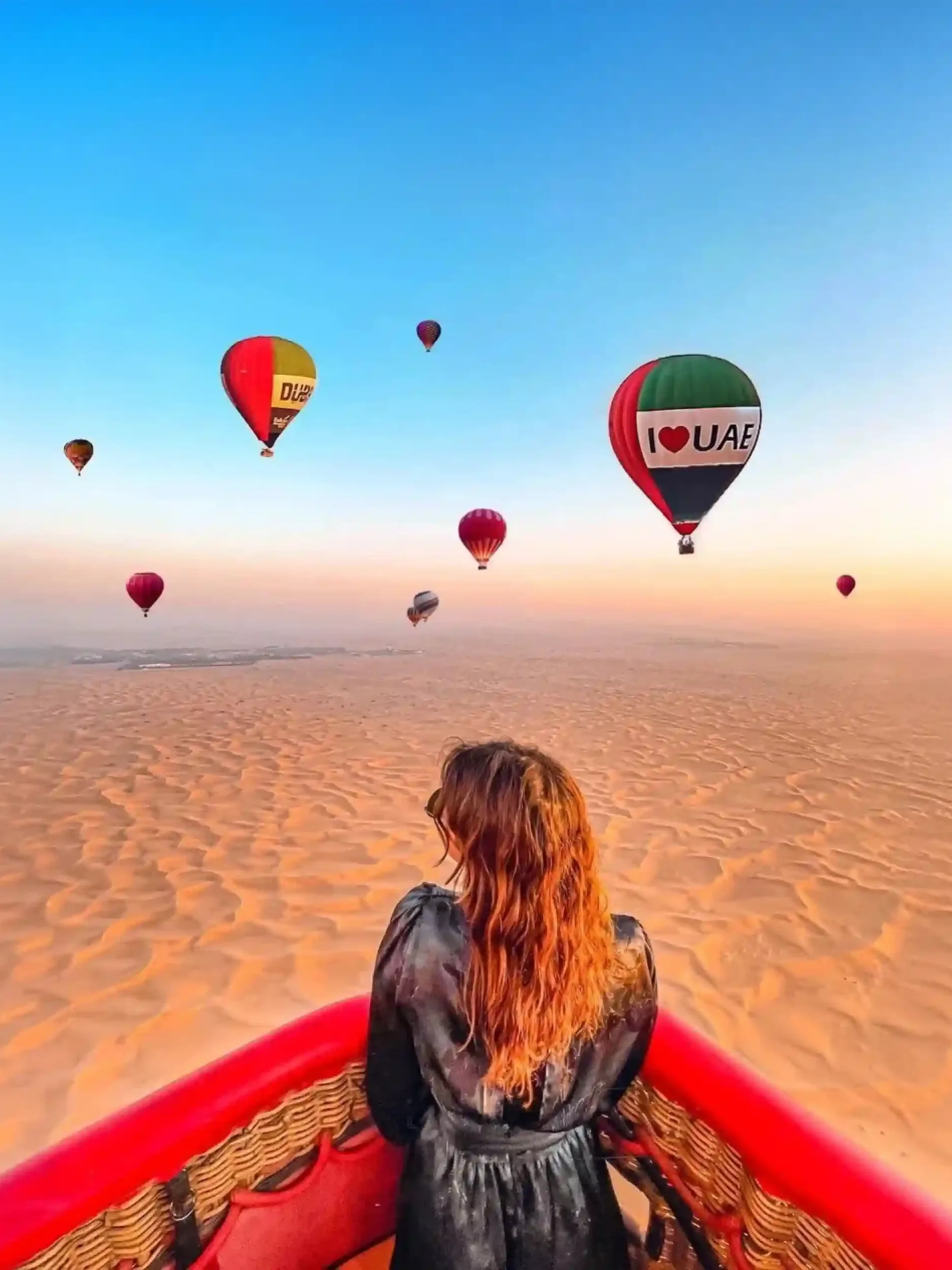 Hot air balloon flying over the Dubai desert at sunrise