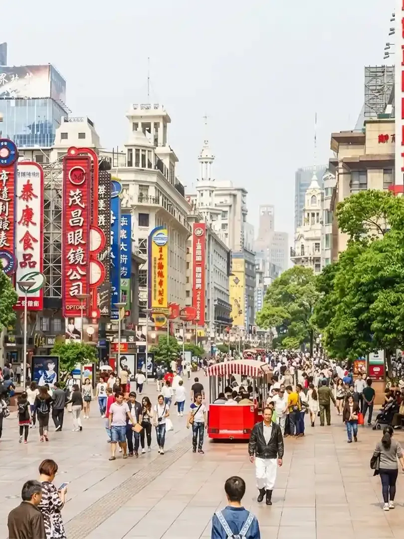 Nanjing Road Shanghai busy shopping street with neon lights, crowds, and retail stores