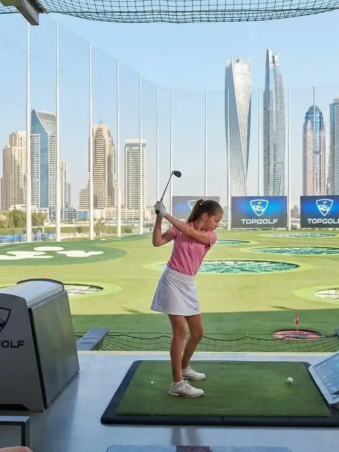 Golfers playing on premium Dubai golf course with skyline view
