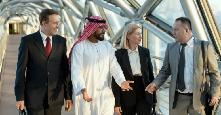 Royal Arabian representative walking and discussing itinerary details with international travel partners in Dubai