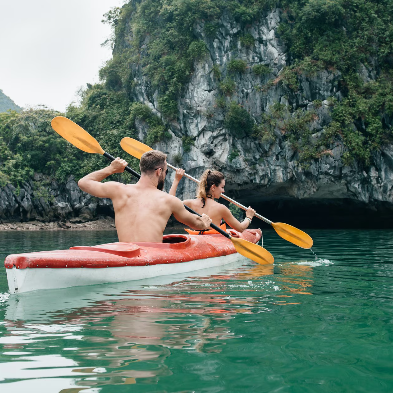 Kayakers paddling through emerald waters and limestone karsts of Lan Hạ Bay Vietnam