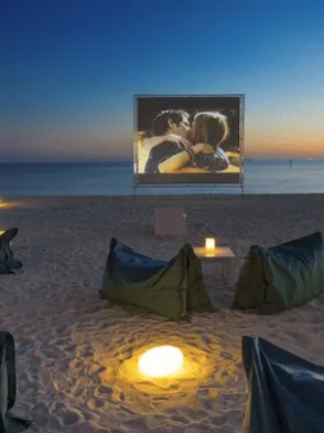 Private beachfront cinema set up on the sand at night in Phuket, Thailand
