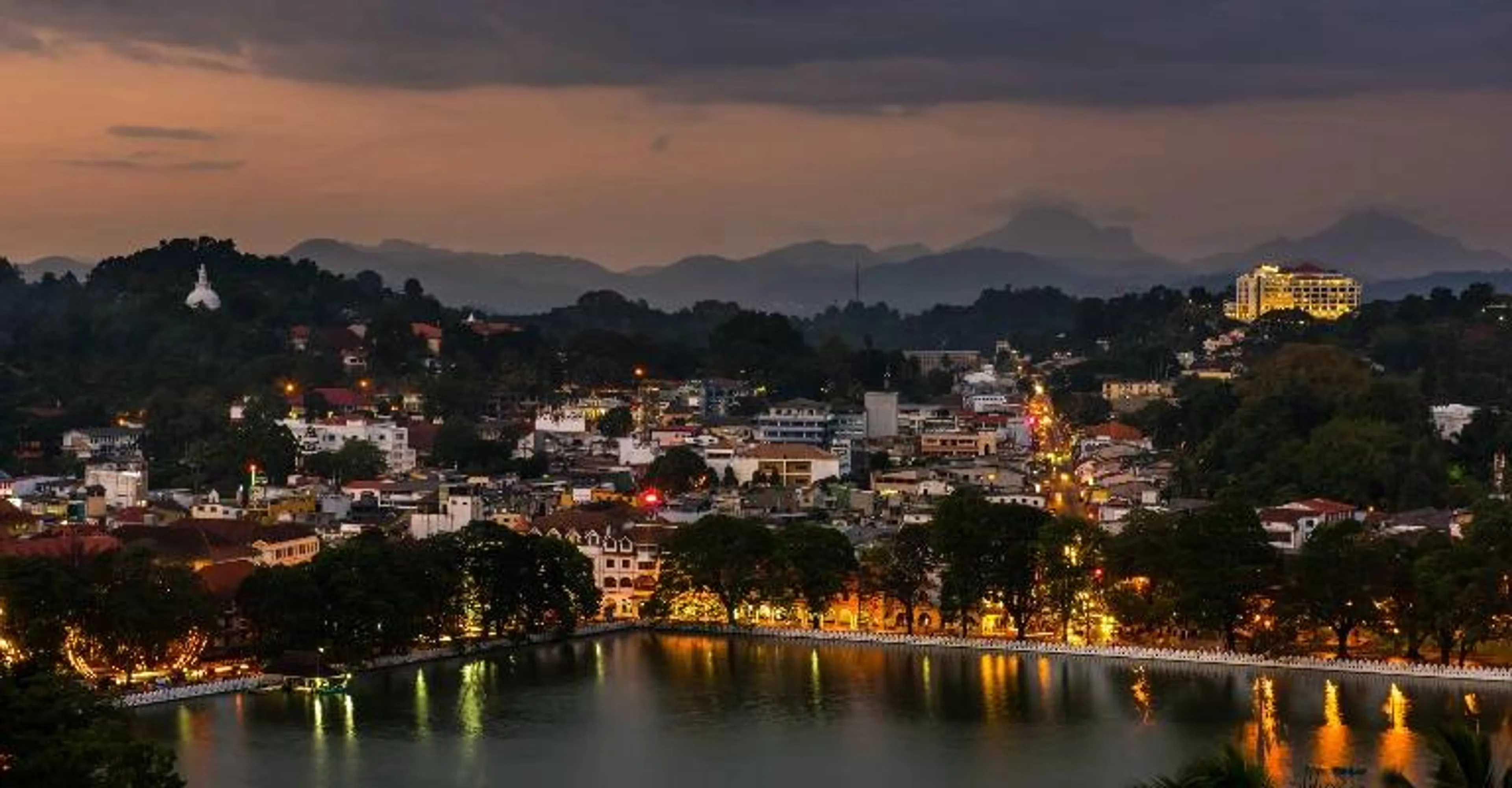 Kandy city skyline and lake at dusk.