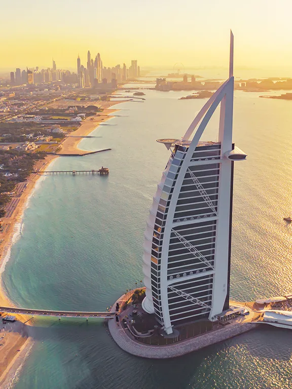 Aerial view of the Burj Al Arab and Dubai coastline at sunset