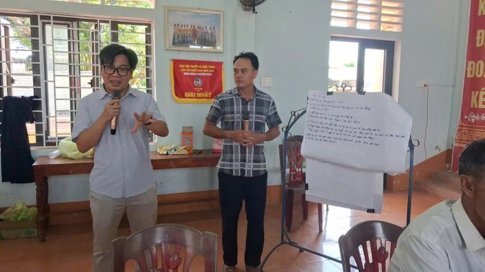 Chuyên gia tập huấn trình bày nội dung bên cạnh bảng giấy ghi kết quả thảo luận