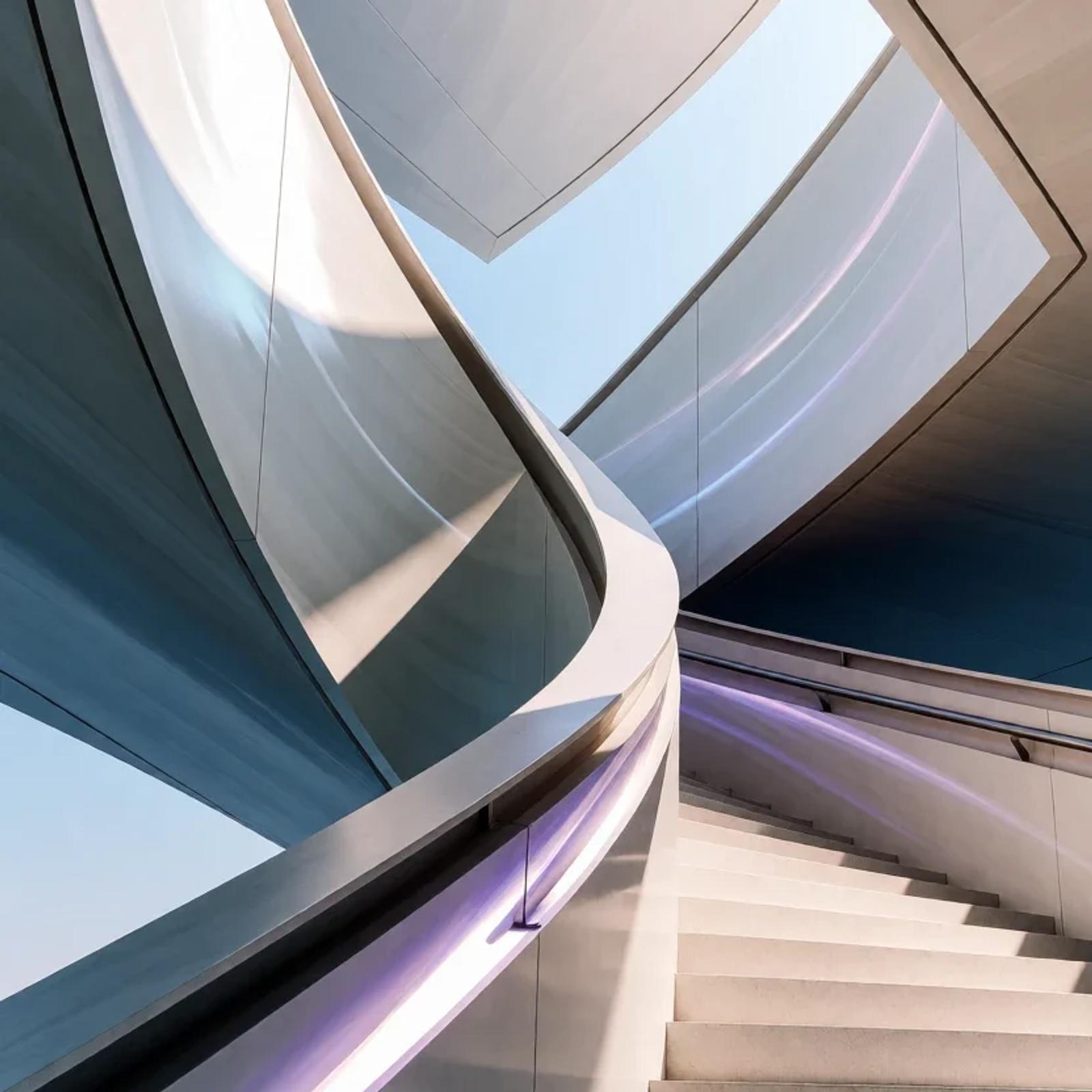 A staircase curving up through bright, open architecture