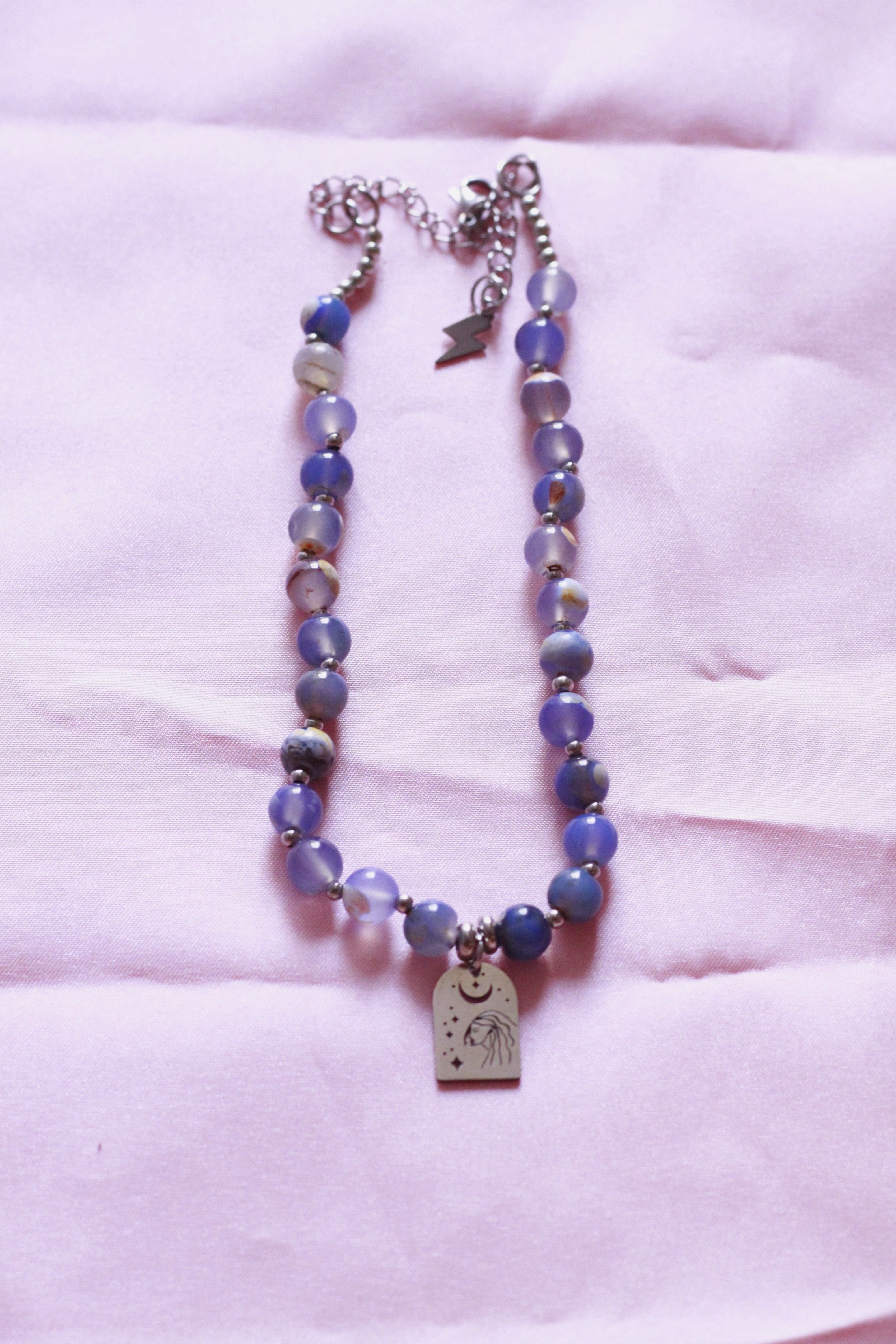 collar de piedras azules y cadena y dije plateados y de acero inoxidable