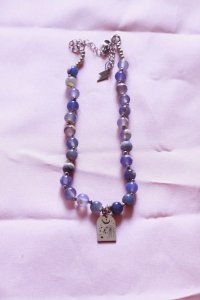 collar de piedras azules y cadena y dije plateados y de acero inoxidable