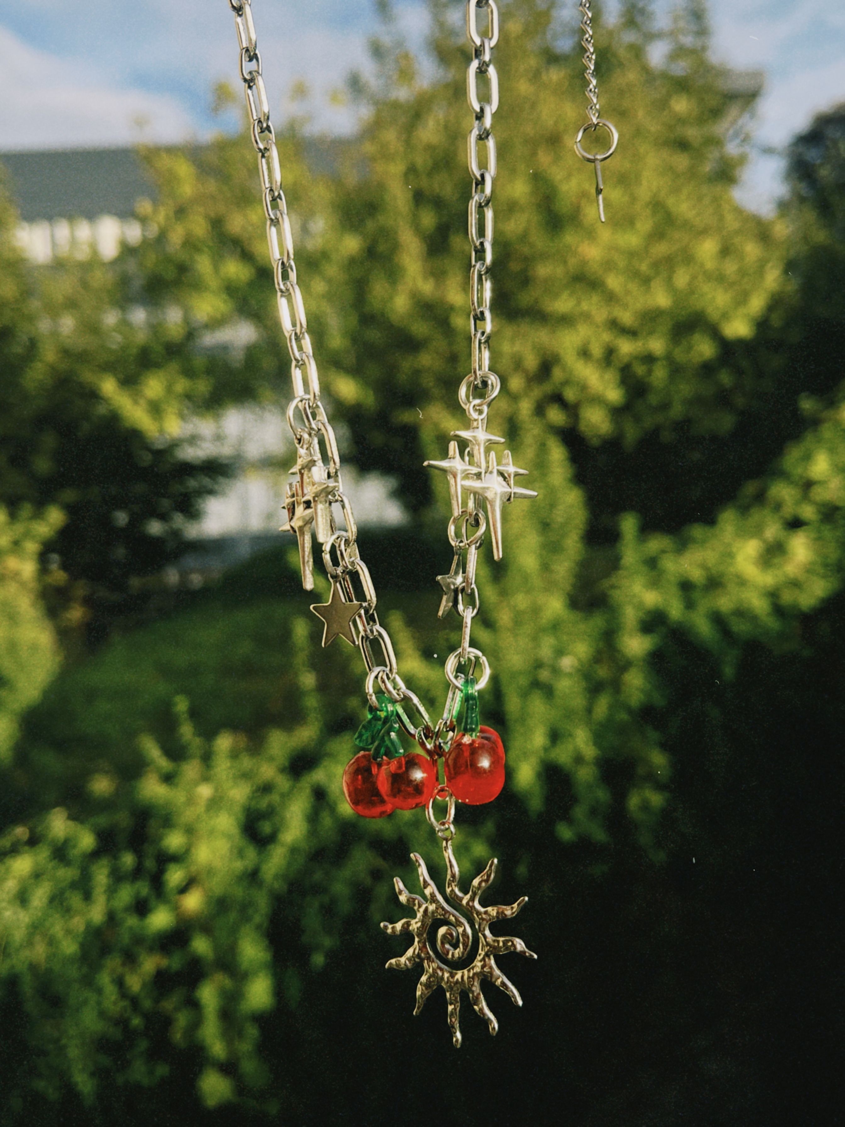 Collar palteado de acero y dijes en acero inoxidable y cerezas de plastico