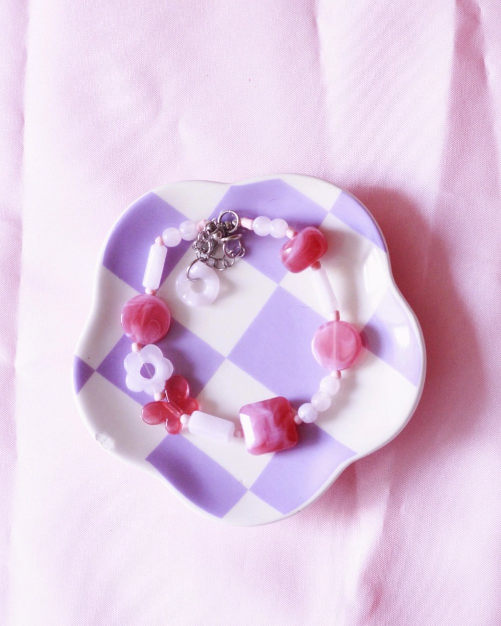 pulsera de cuentas de plástico en tonos rosa y fucsia