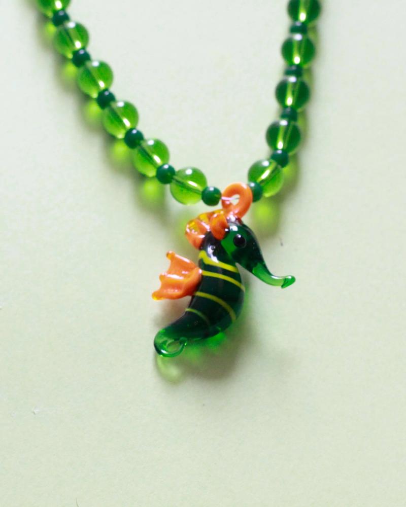 Collar de piedras verdes y dije de vidrio