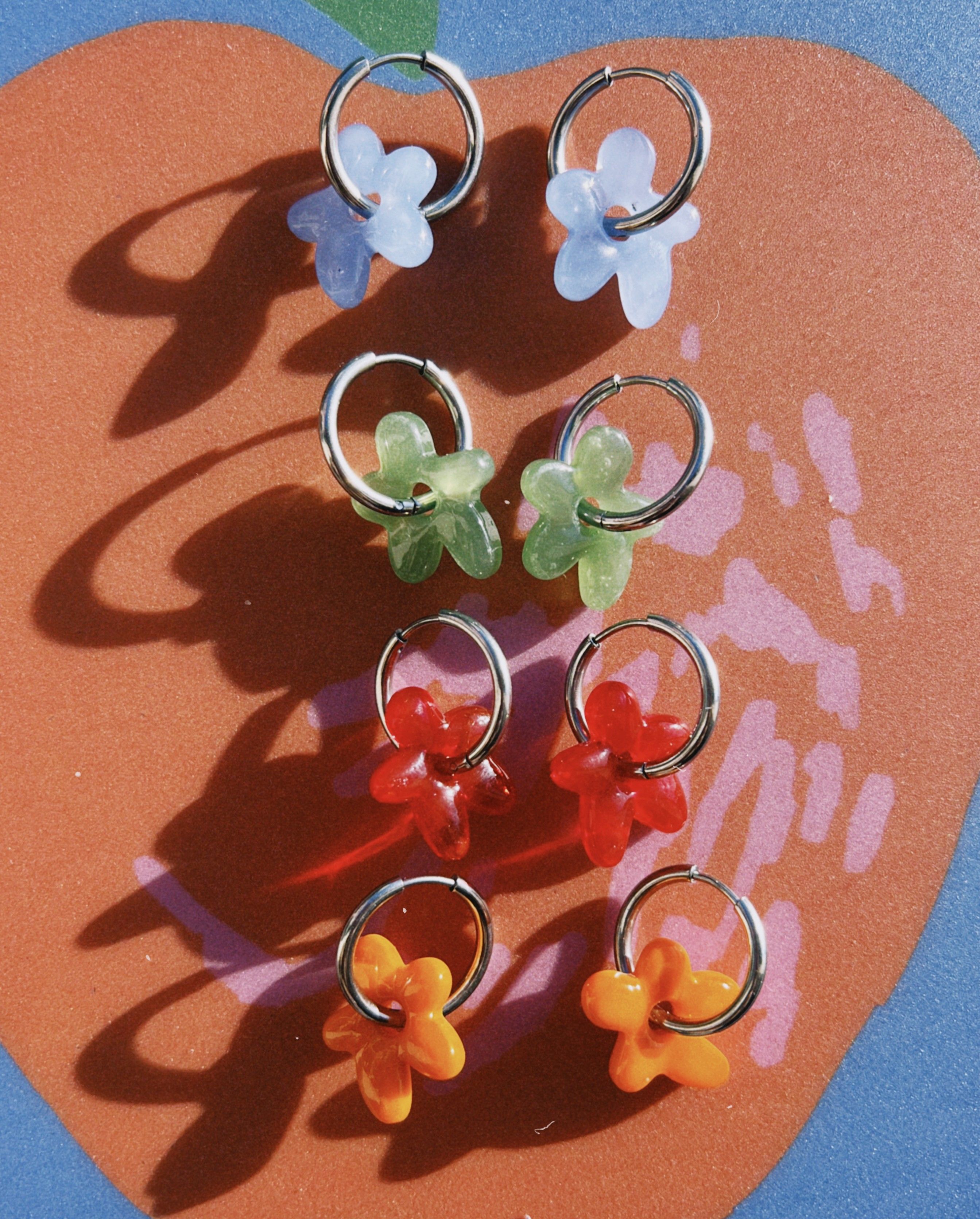 pendientes de acero quirúrgico con dijes de flor de distintos colores