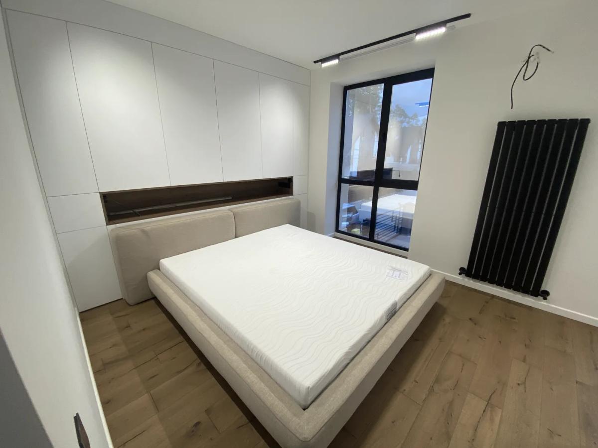 Dormitorio reformado con armarios empotrados, suelo de madera y radiador de diseño, Valencia