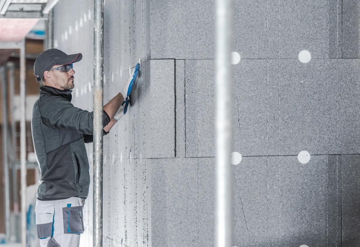 Operario colocando paneles de EPS grafito en un sistema SATE de fachada