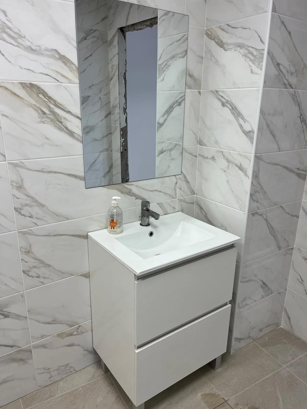 Aseo del local con porcelánico efecto mármol y mueble de lavabo