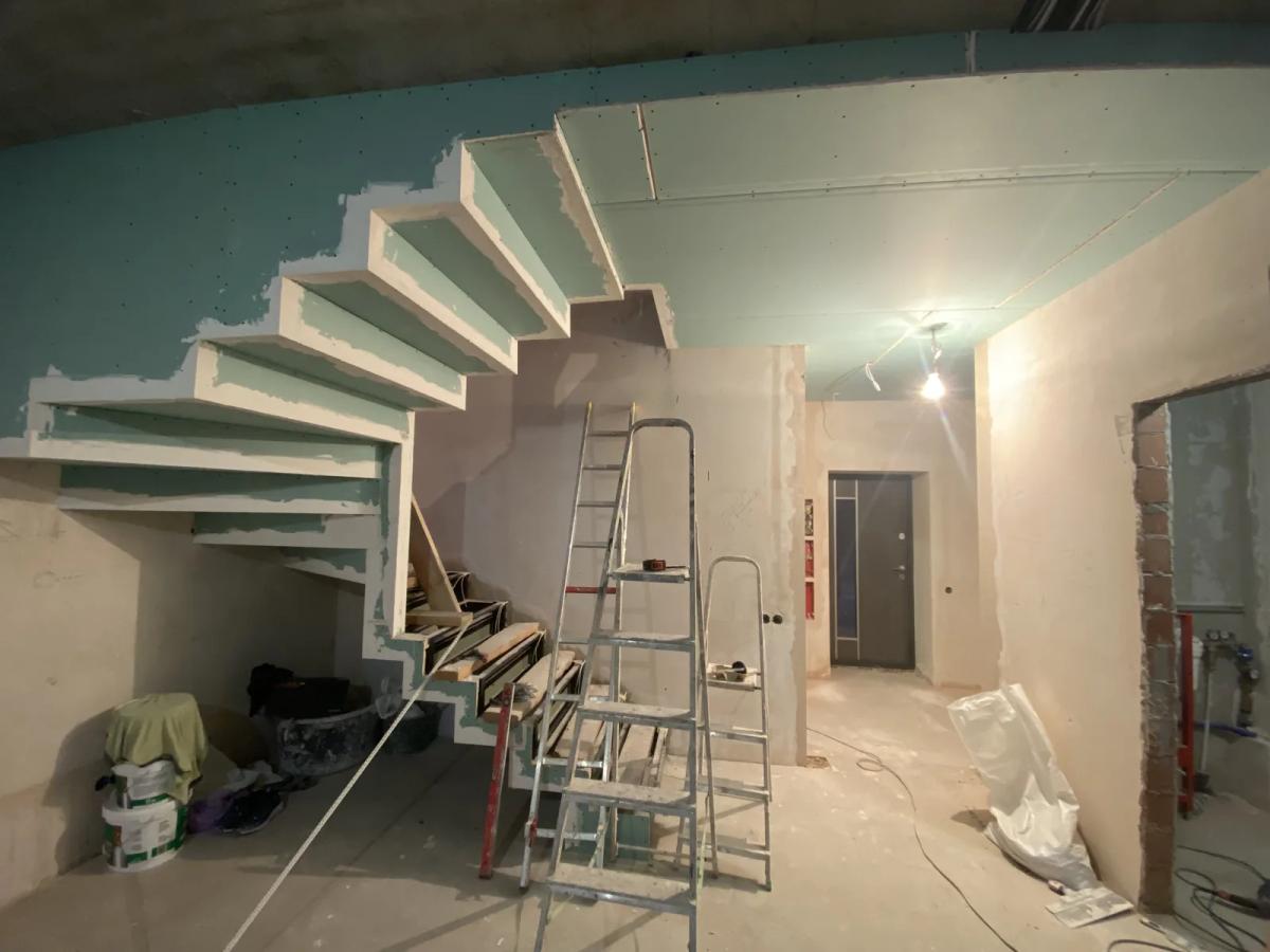 Escalera revestida con pladur curvado durante una reforma en Valencia