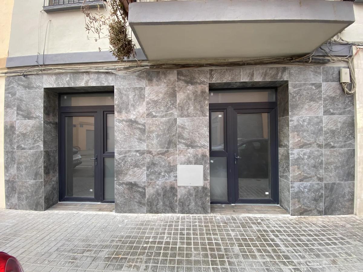 Fachada de local comercial terminada con revestimiento porcelánico y carpintería nueva, Valencia
