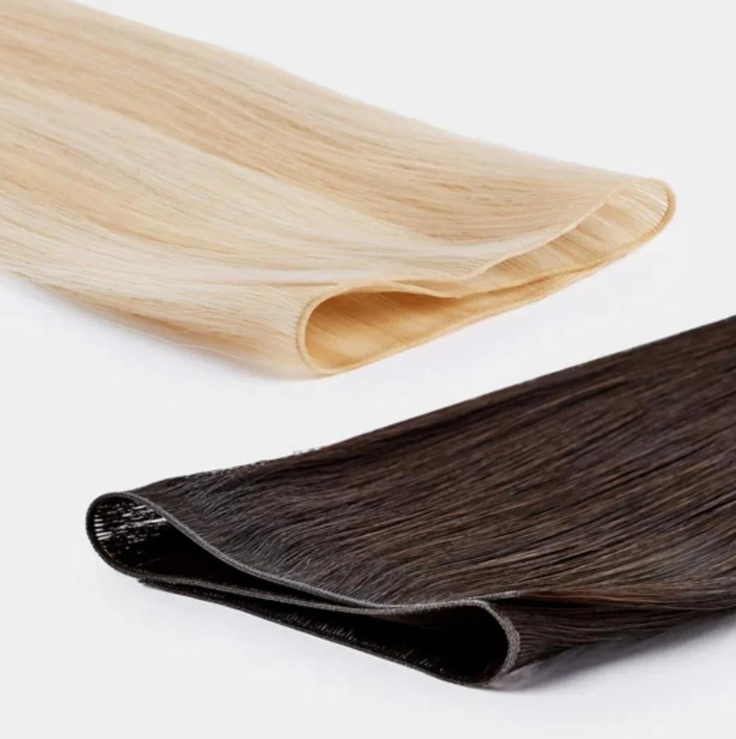 Two folded hair extension wefts, one pale blonde and one dark brunette