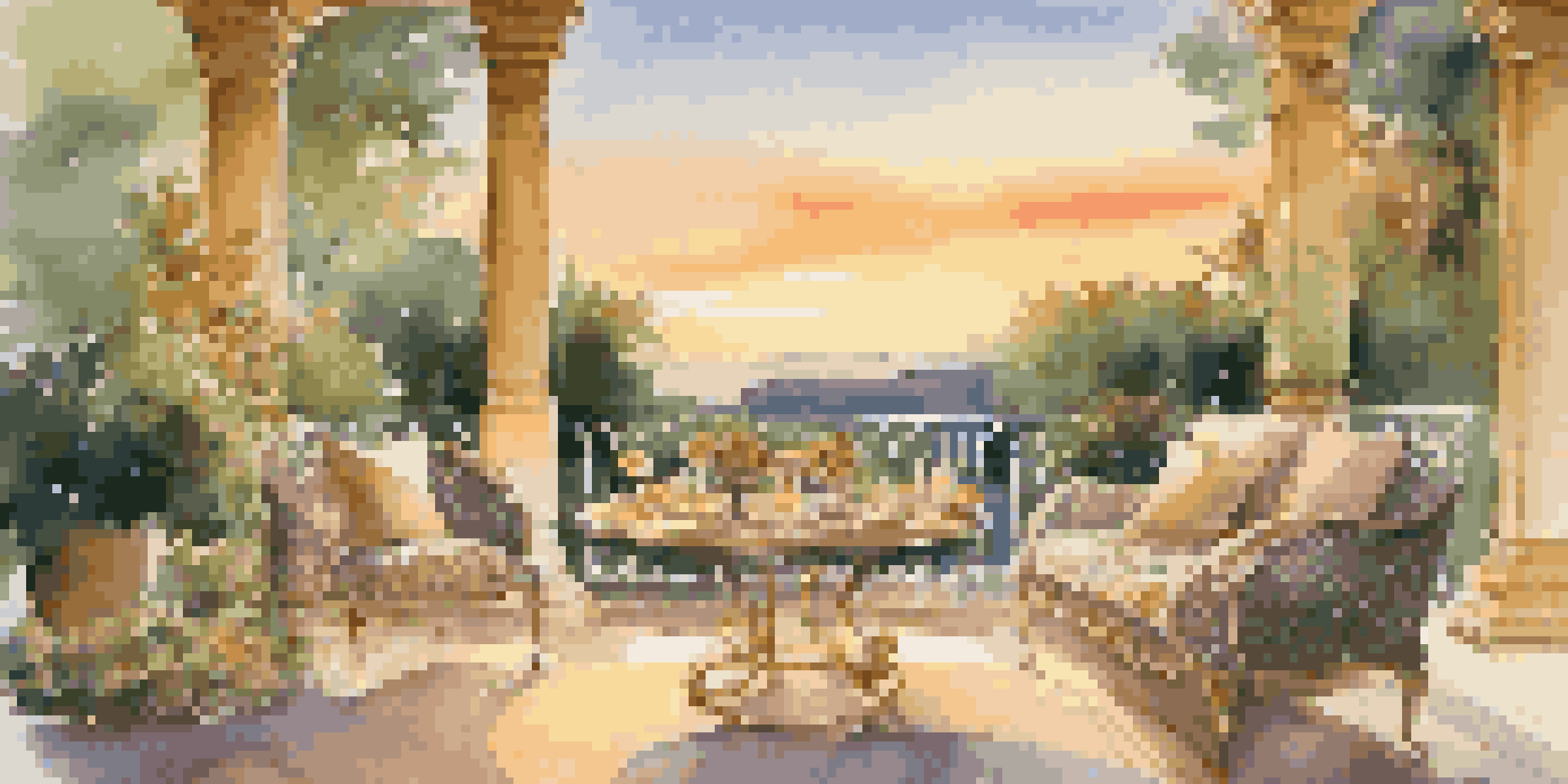 A beautiful outdoor terrace with elegant furniture and a sunset view, featuring a fine dining setup for two amidst lush greenery.