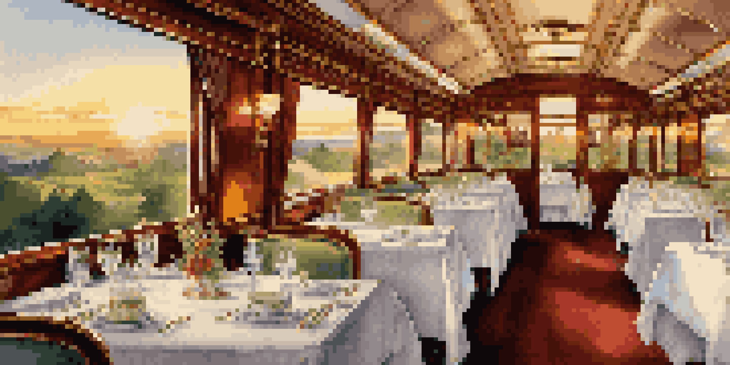An elegant train dining car with beautifully set tables and scenic views outside the window during sunset.