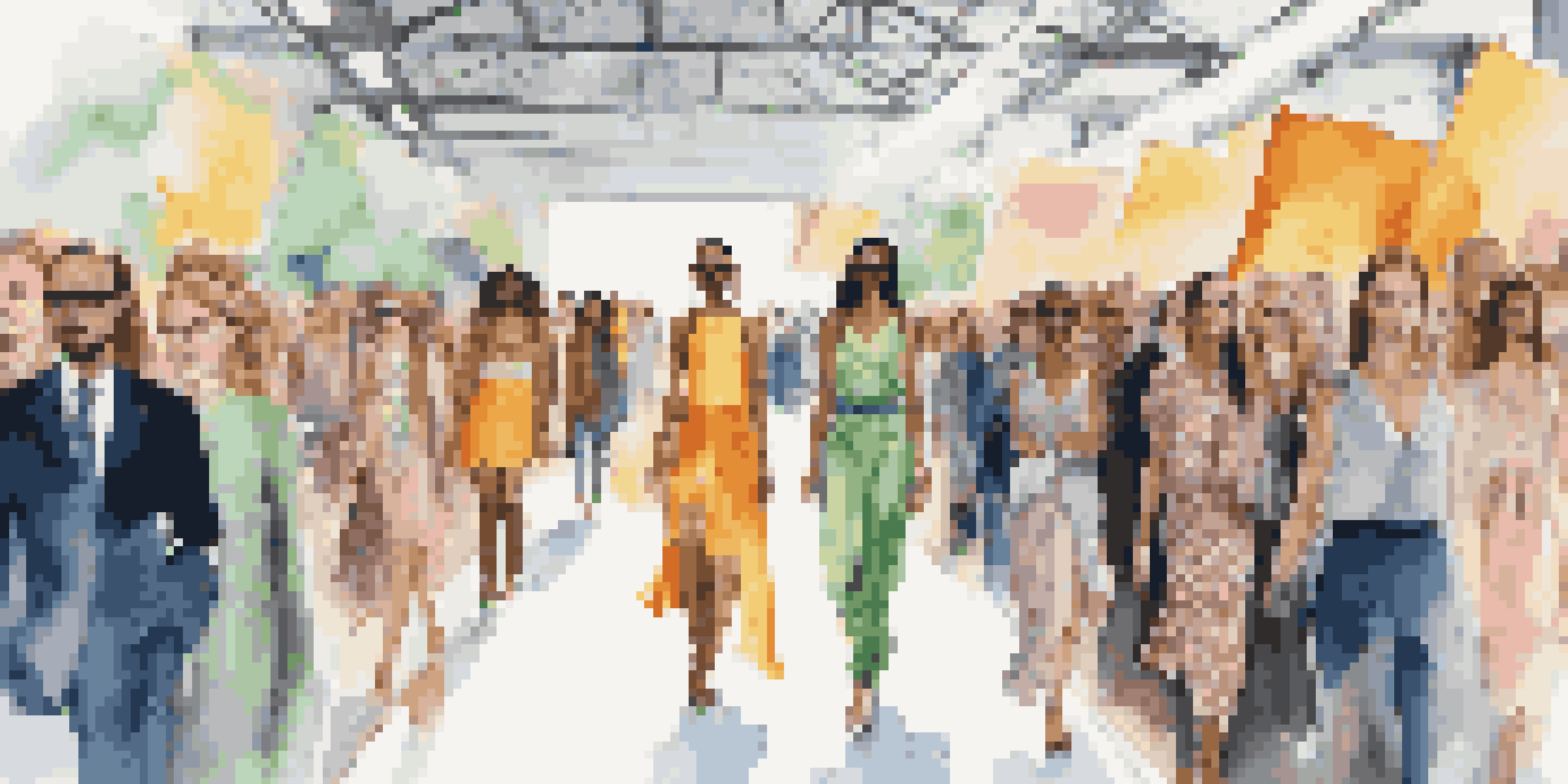 A lively fashion week runway featuring models in sustainable clothing with an engaged audience taking pictures.