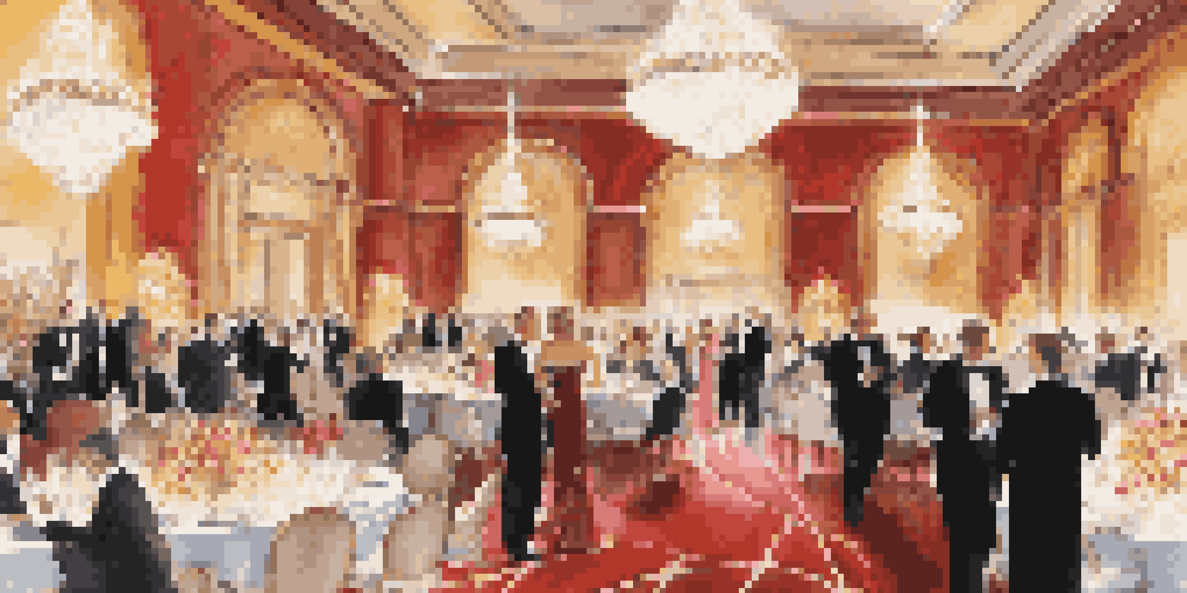 A beautifully decorated ballroom for an awards ceremony, with guests in formalwear enjoying the event.