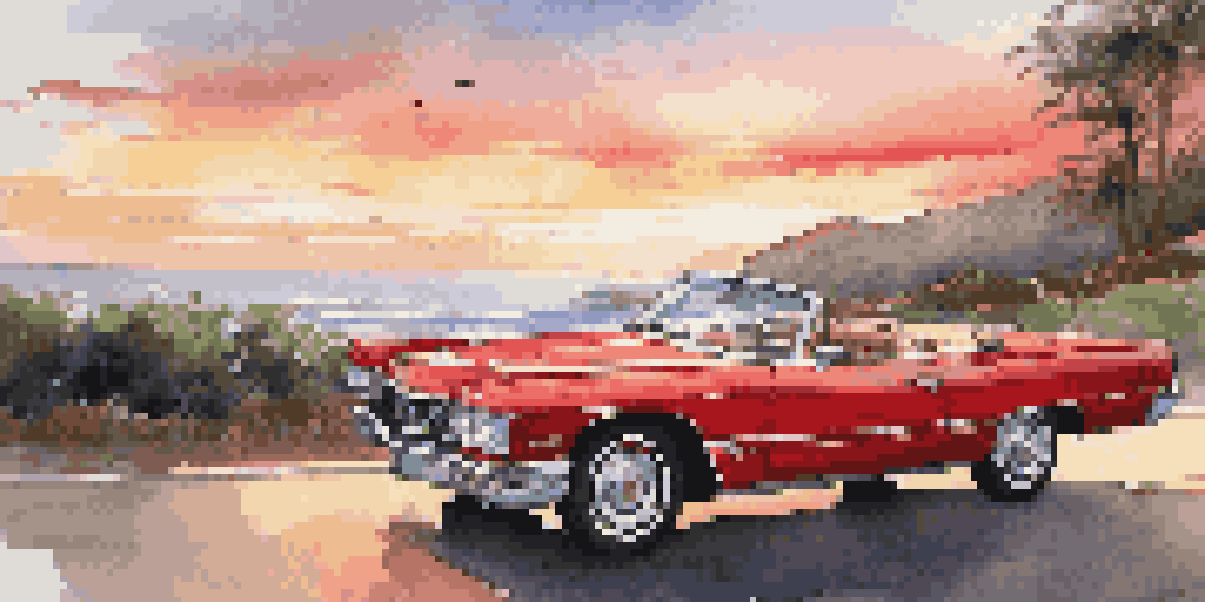 A luxurious red convertible parked on a scenic coastal road during sunset, with ocean waves in the background.