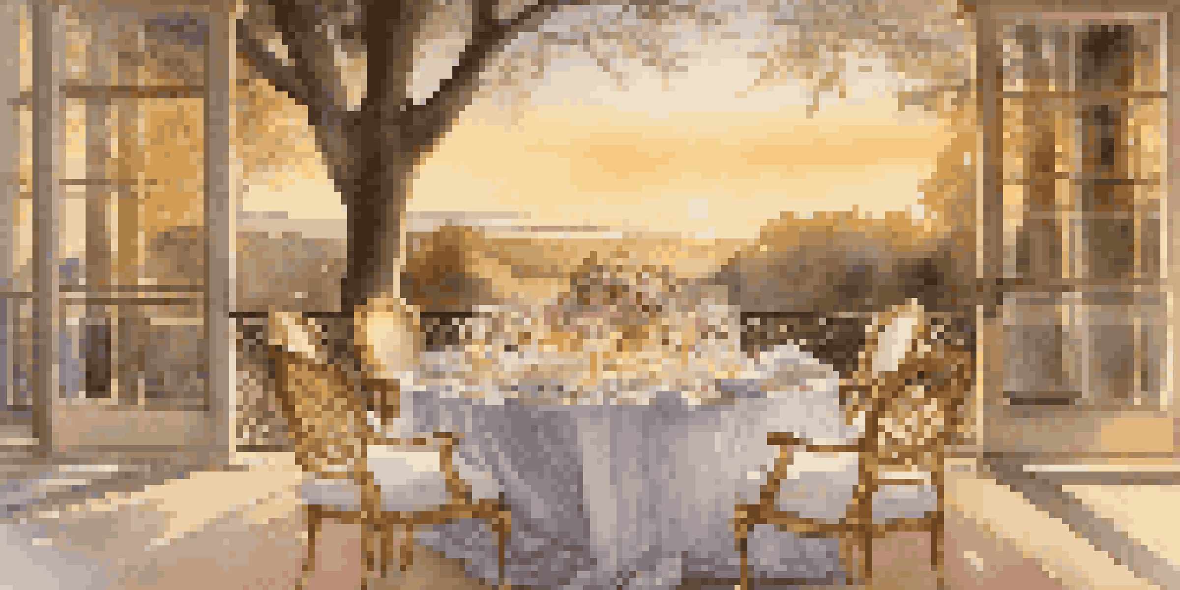 An elegantly set outdoor dining table at sunset, with fine china and a floral centerpiece, surrounded by nature.