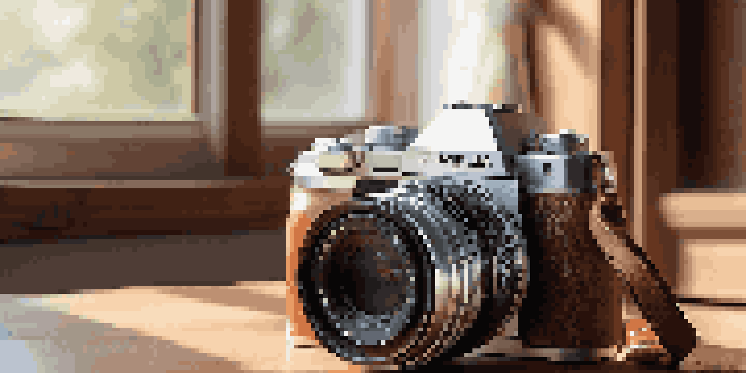 A detailed view of a mirrorless camera on a wooden table with luxurious photography accessories.