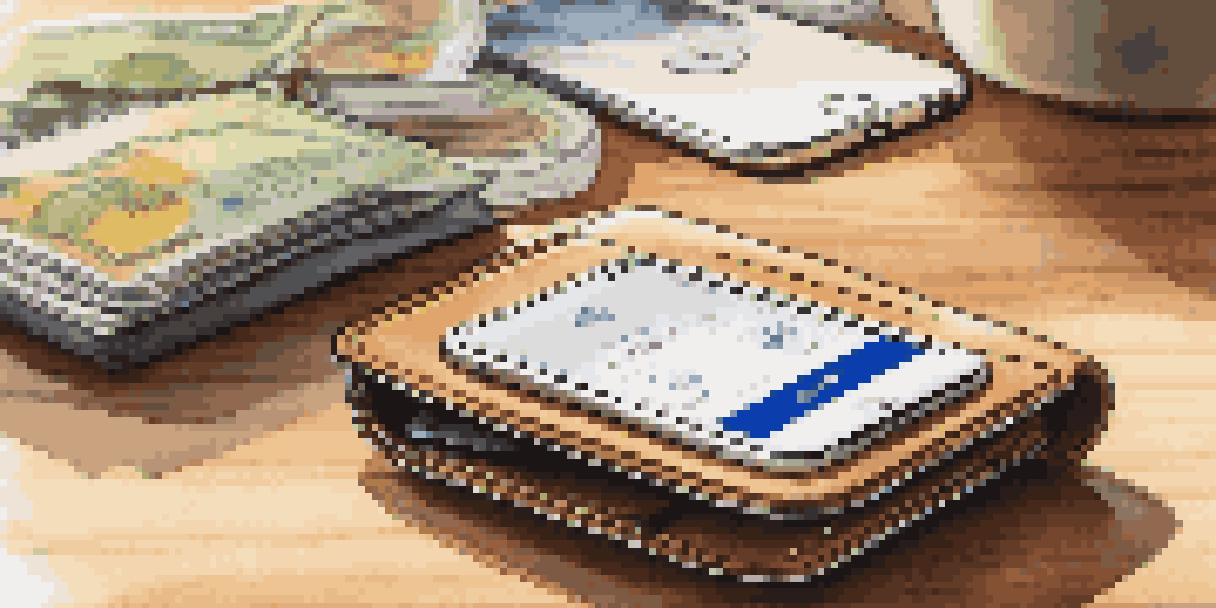 A smart wallet on a wooden table, open to show cards and cash, with a smartphone displaying a GPS tracking app in the background.