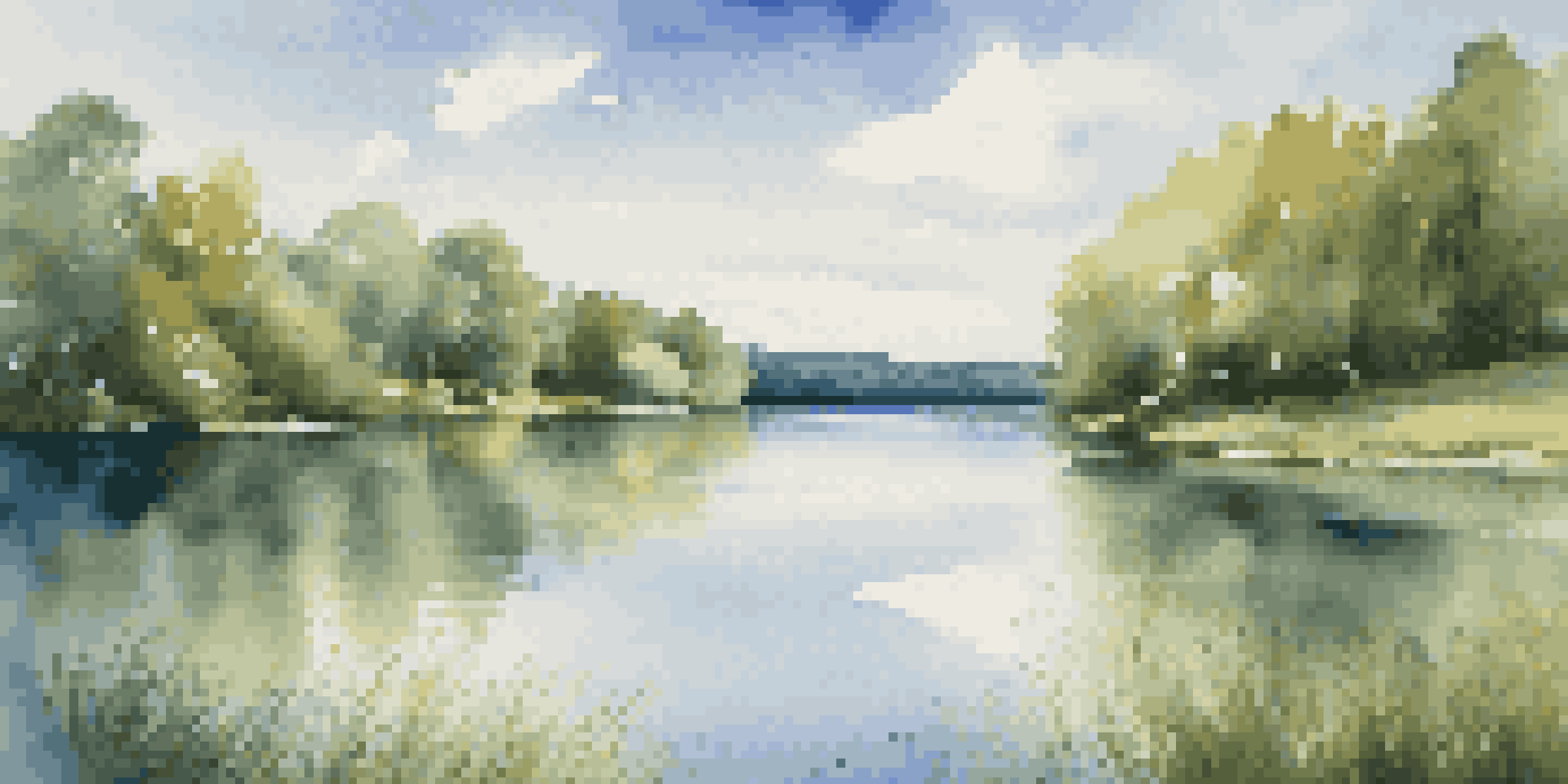 A peaceful lake surrounded by green trees and a bright blue sky.