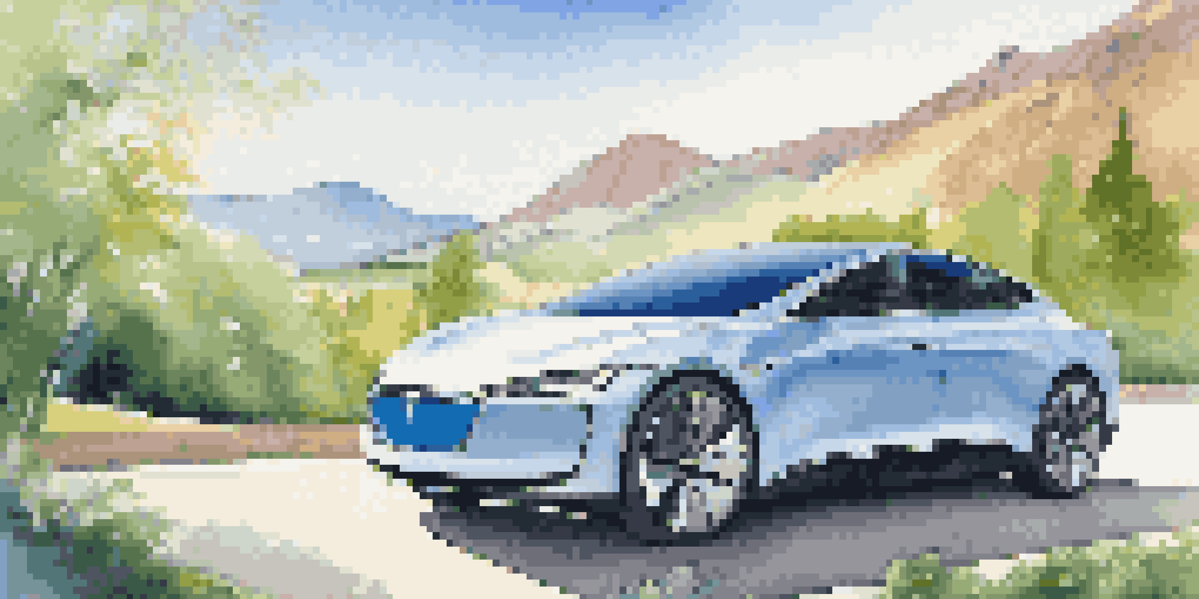 A sleek electric car in a beautiful natural landscape with mountains and greenery.