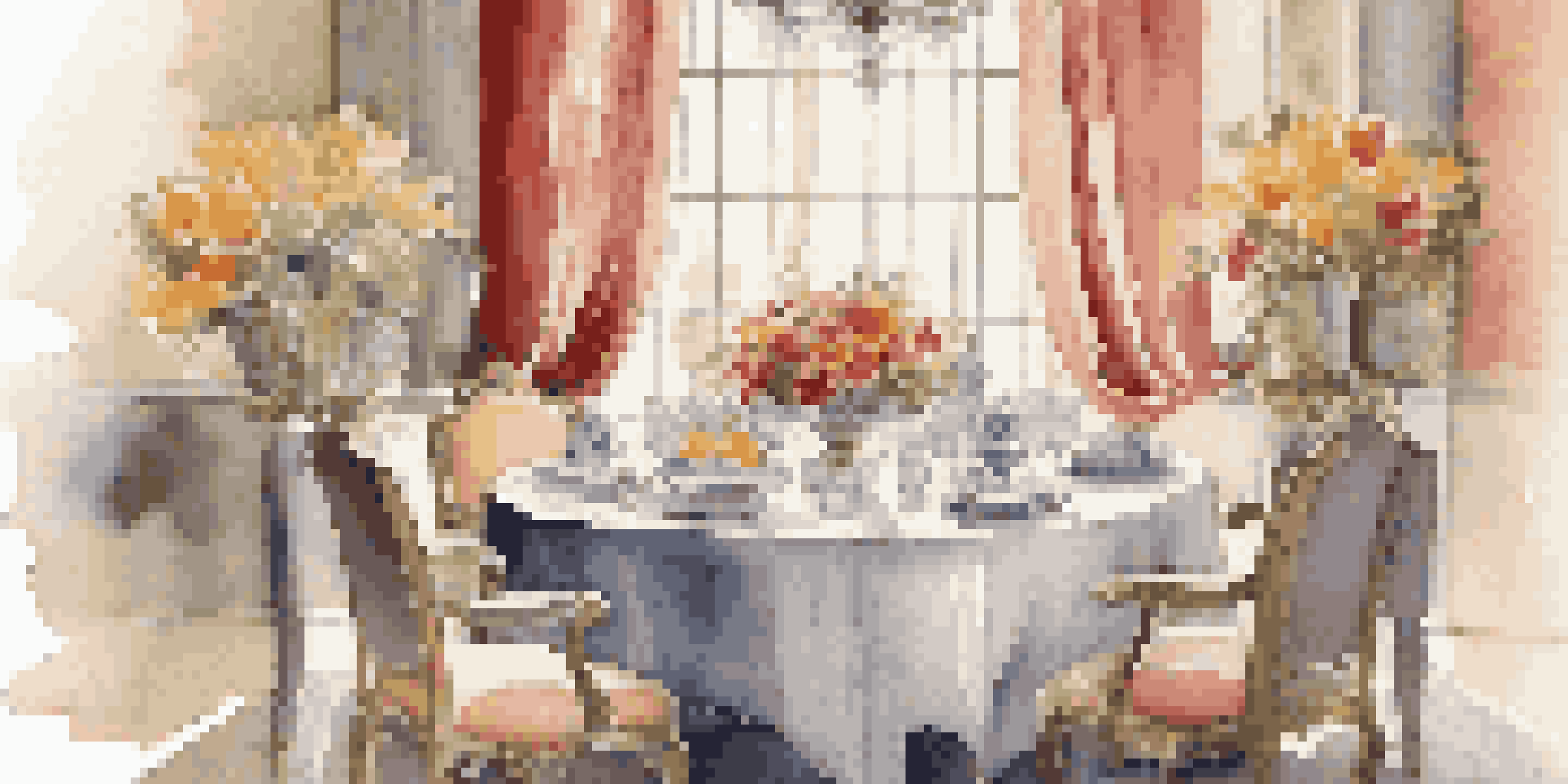 A beautifully arranged dining table with elegant tableware and a colorful flower centerpiece in a softly lit room.