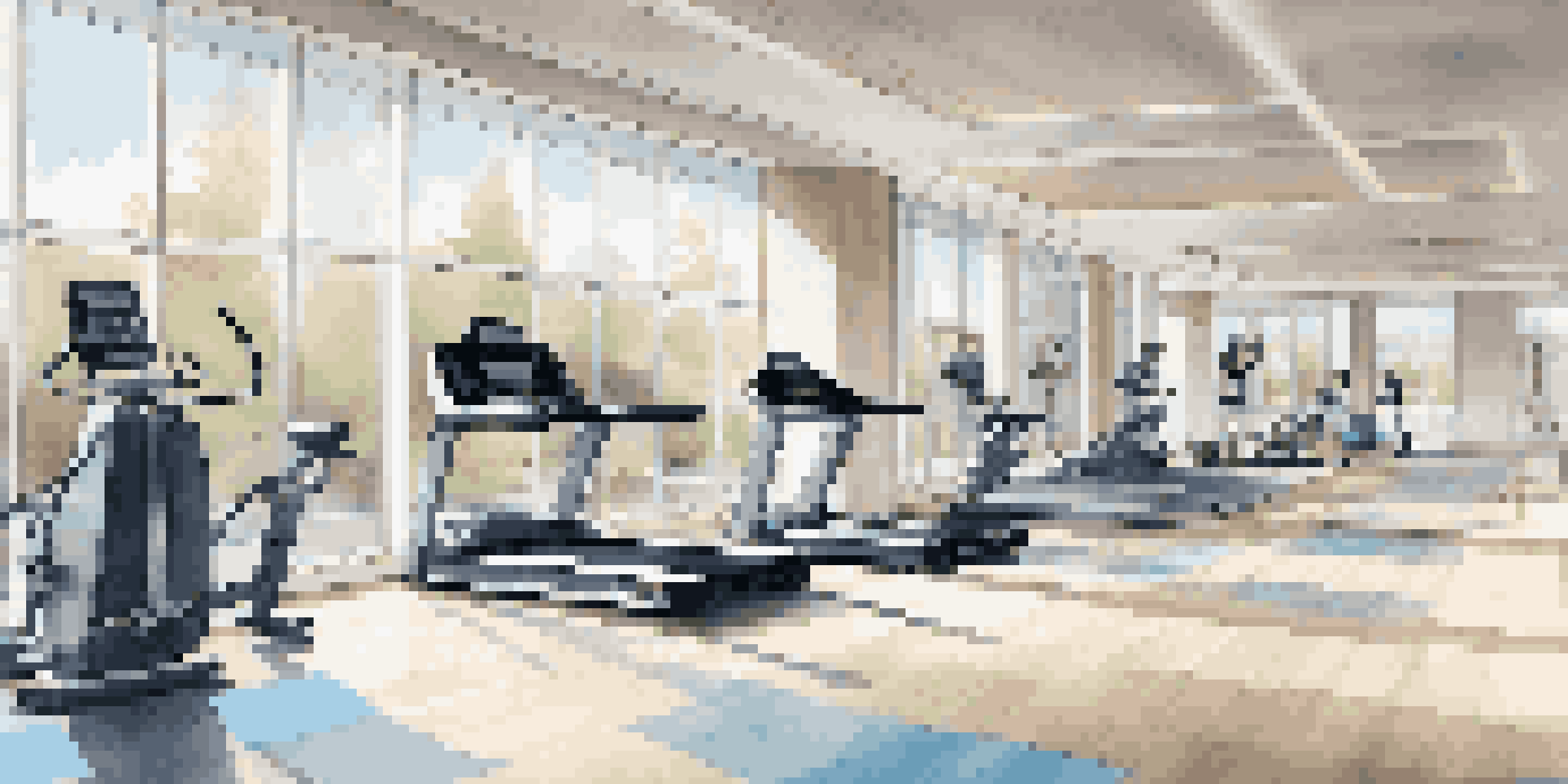 Interior view of a luxury gym with high-end equipment and natural light.