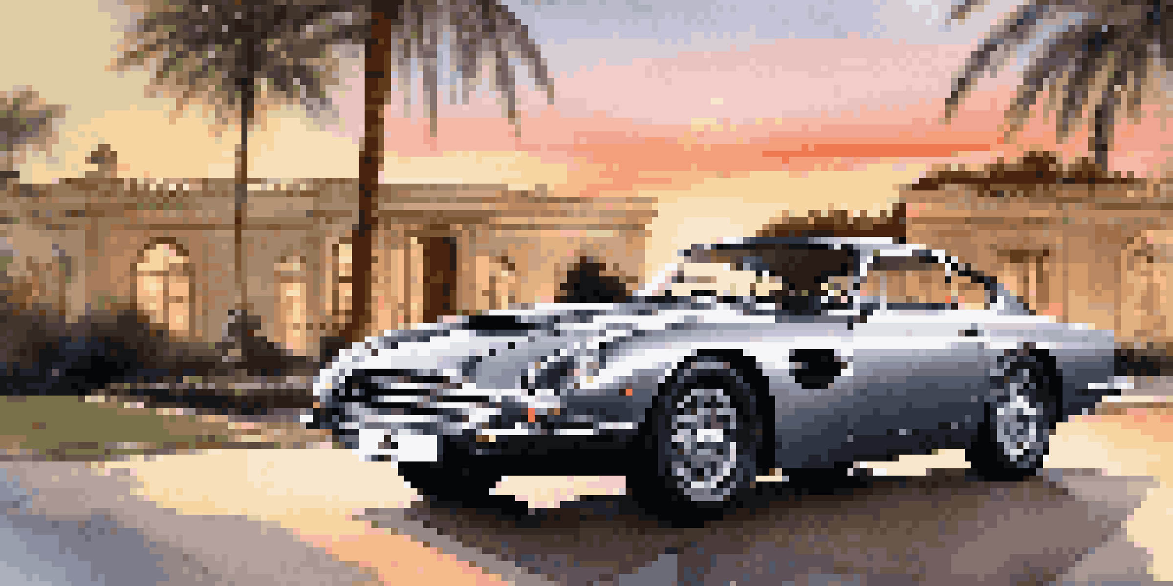 A silver Aston Martin parked in front of a luxurious mansion during sunset, with palm trees in the foreground.