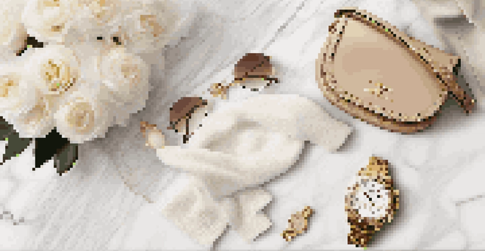 A flat lay of a designer handbag, sunglasses, and a gold watch on a marble surface, with white flowers and a cashmere scarf, illuminated by warm natural light.