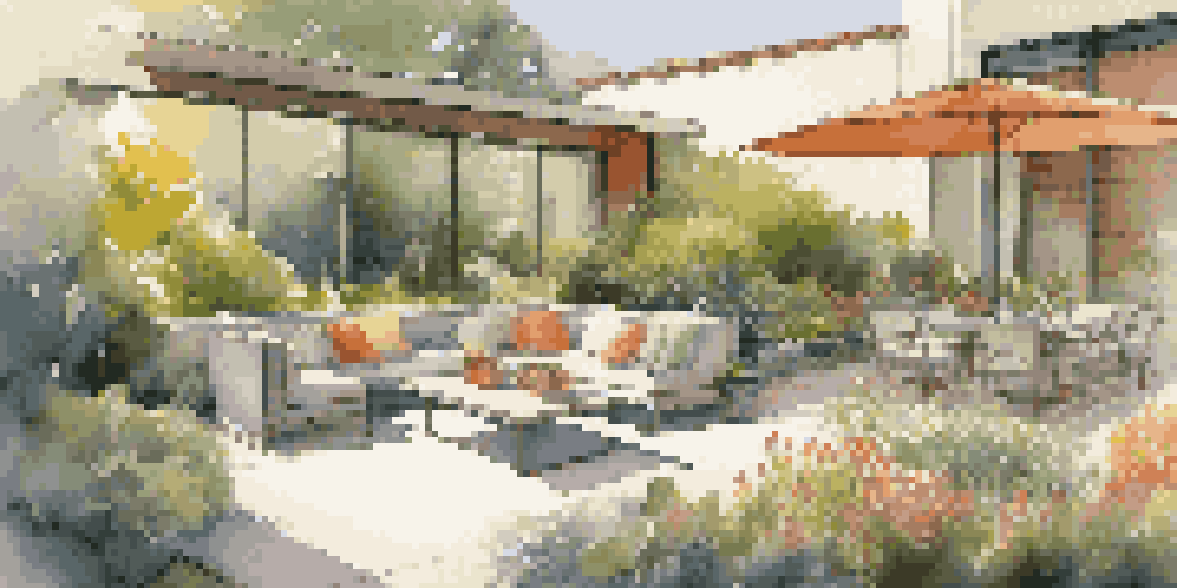 A beautiful garden filled with colorful flowers and greenery in a modern luxury home, with a greywater recycling system integrated into the design.